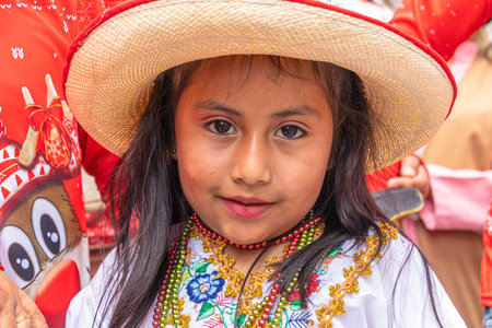 Cuenca, Ecuador - December 24, 2022: Pase del NiÃ±o Viajero Christmas Parade in Cuenca. Beautiful little girl wearing an embroidered blouse and a real Panama hat looks at the cameraのeditorial素材