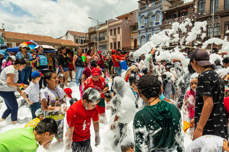 Cuenca, Ecuador - February 18, 2023: Annual Carnival event in Cuenca. The audience and participants have fun while people are sprayed with foam from a fire truck on San Francisco Pのeditorial素材