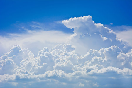Group dense clouds before the storm against a blue sky. Clouds lit by the rays of the sun.