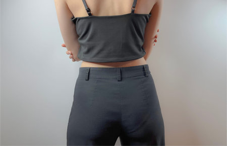 a young girl in black jeans and a black top is standing with her back to usの写真素材