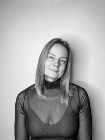 mature woman with long blond hair in a black turtleneckの写真素材