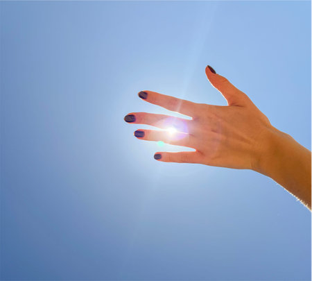 women's hands on the background of a summer blue sky with cloudsの写真素材
