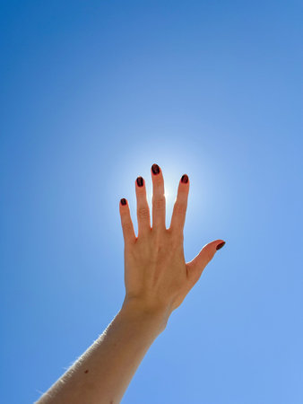 women's hands on the background of a summer blue sky with clouds