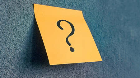 Angled view of a question mark on an adhesive noteの写真素材