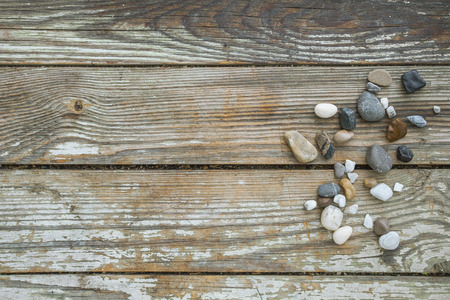 Sea stones on wooden background, simplicity, daylight, space around stones, one by oneの写真素材