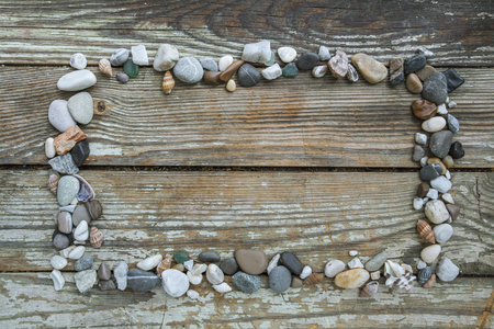 Sea stones on wooden background, simplicity, daylight, space around stones, one by oneの写真素材