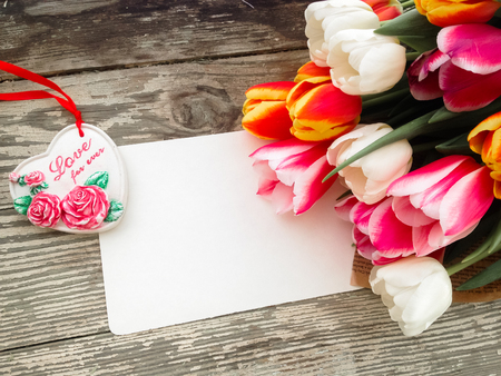 Tulips flowers bunch on dark barn wood planks background. Empty space for copy, text, lettering. Postcard, greeting card template.の写真素材