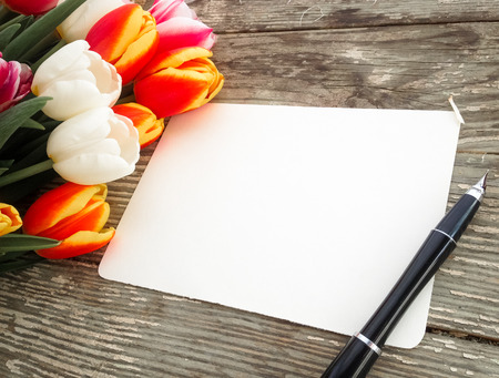 Tulips flowers bunch on dark barn wood planks background. Empty space for copy, text, lettering. Postcard, greeting card template.の写真素材