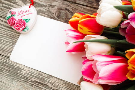 Tulips flowers bunch on dark barn wood planks background. Empty space for copy, text, lettering. Postcard, greeting card template.の写真素材