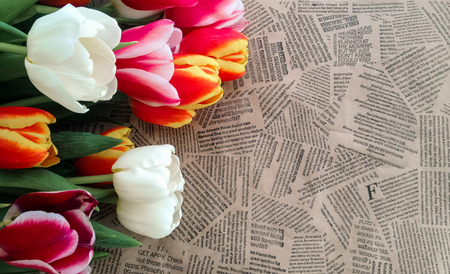 Tulips flowers bunch on Vintage newspaper background. Empty space for copy, text, lettering.の写真素材