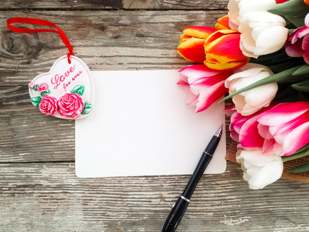 Tulips flowers bunch on dark barn wood planks background. Empty space for copy, text, lettering. Postcard, greeting card template.の写真素材