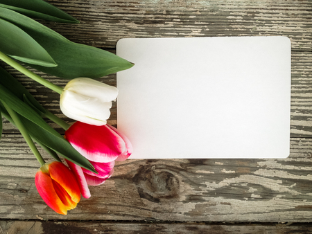 Tulips flowers bunch on dark barn wood planks background. Empty space for copy, text, lettering. Postcard, greeting card template.の写真素材