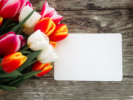 Tulips flowers bunch on dark barn wood planks background. Empty space for copy, text, lettering. Postcard, greeting card template.の写真素材