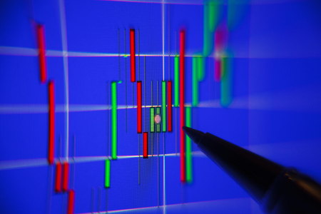 Financial graph on a computer monitor screen. Businessman writing the trading graph of graph analysis for stock exchange, finance, investment and economy. Graph analysis background on LED screen.の写真素材