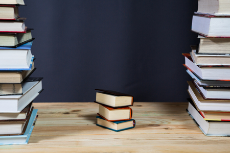 Pile of various books on bright wooden background. With copy space for your textの写真素材