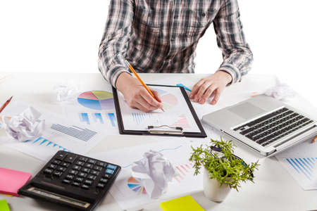Businessman holding a pen is working with graph documents. Stock market chart and finger pointing on tablet in office.の写真素材