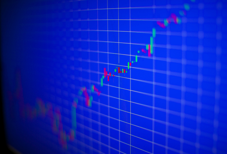 Financial graph on a computer monitor screen. Background stock chart. Analysing stock market data on a monitor. Blue background with stock chart. Finance concept. Tools of technical analysis.の写真素材