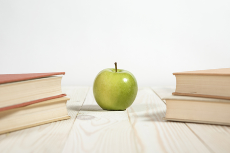 Stack of books and apple on the table. Copy space for text. Selective focus. Knowledge conceptの写真素材