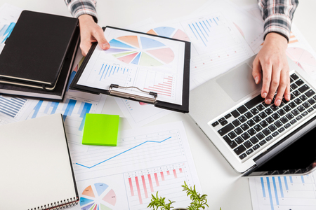 Businessman working with graph documents. Stock market chart and finger pointing on tablet in office.の写真素材