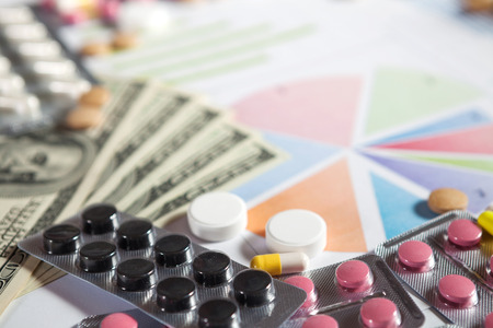Medical marketing and healthcare business analysis report with graph and many. Pile of pills in blister packs backgroundの写真素材