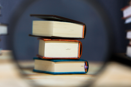 Pile of various books on bright wooden background. With copy space for your textの写真素材