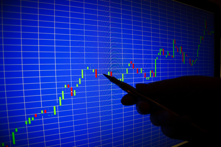 Financial graph on a computer monitor screen. Businessman writing the trading graph of graph analysis for stock exchange, finance, investment and economy. Graph analysis background on LED screen.の写真素材