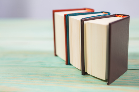 Pile of miniature books on wooden background. With copy space for your textの写真素材
