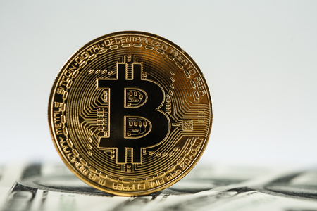 New virtual money Golden bitcoin coin on us dollars background . Cryptocurrency. Business and Trading concept.の写真素材