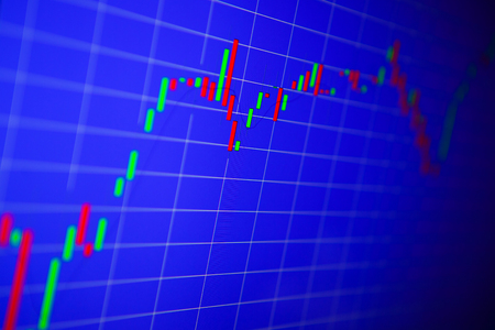 Financial graph on a computer monitor screen. Background stock chart. Analysing stock market data on a monitor. Blue background with stock chart. Finance concept. Tools of technical analysis.の写真素材