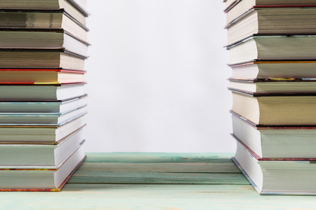 Pile of various books on bright wooden background. With copy space for your textの写真素材