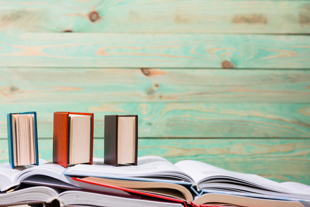 Stack of open books pile of various miniature books on wooden background. With copy space for your textの写真素材