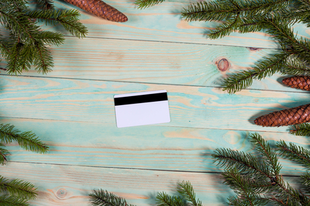 Christmas background with spruce branches and credit card on wooden board with copy space. Online shopping.の写真素材
