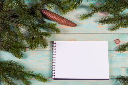 Christmas background with spruce branches on wooden board with notebook copy spaceの写真素材