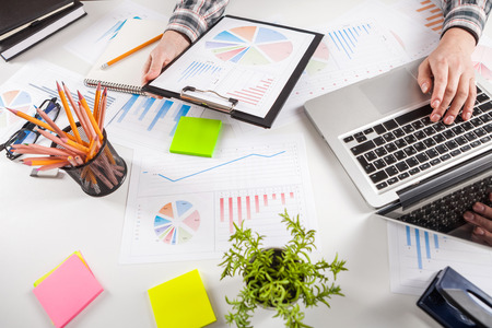 Businessman holding a pen is working with graph documents. Stock market chart and finger pointing on tablet in office.の写真素材