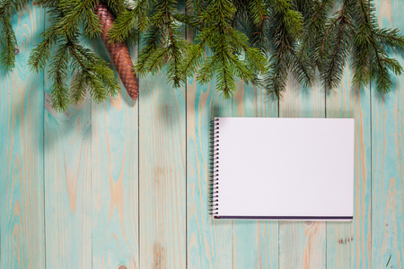 Christmas background with spruce branches on wooden board with notebook copy spaceの写真素材