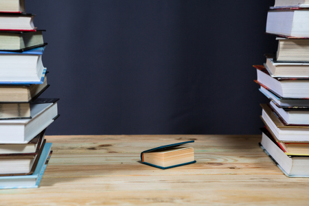 Pile of various books on bright wooden background. With copy space for your textの写真素材