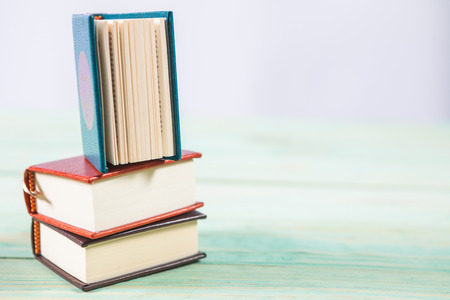 Pile of miniature books on wooden background. With copy space for your textの写真素材