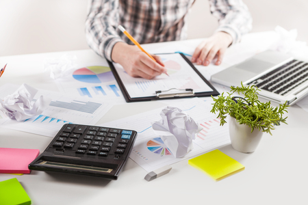 Businessman holding a pen is working with graph documents. Stock market chart and finger pointing on tablet in office.の写真素材