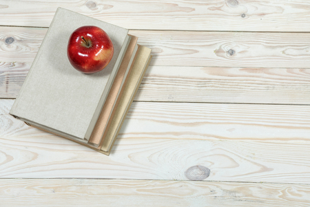 Stack of books and apple on the table. Copy space for text. Selective focus. Knowledge conceptの写真素材