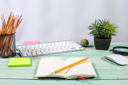 Office desk table with computer, supplies, flower and coffee cup. Copy spaceの写真素材