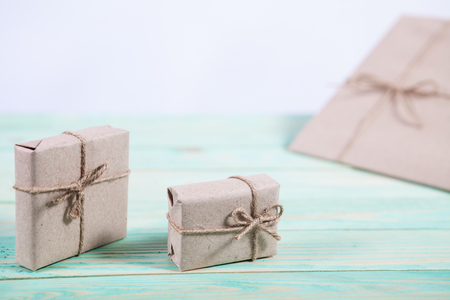 Presents for any holiday concept. Border of decorative gifts wrapped kraft paper tied with tourniquet for christmas, valentine day or birthdayの写真素材