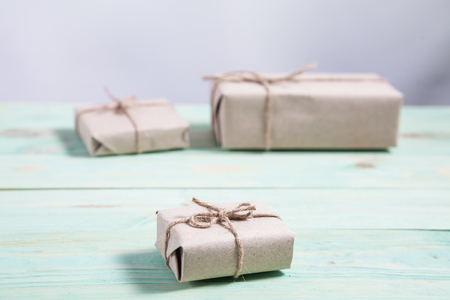 Presents for any holiday concept. Border of decorative gifts wrapped kraft paper tied with tourniquet for christmas, valentine day or birthdayの写真素材