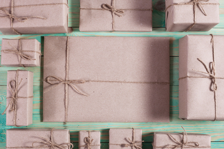 Presents for any holiday concept. Border of decorative gifts wrapped kraft paper tied with tourniquet for christmas, valentine day or birthdayの写真素材