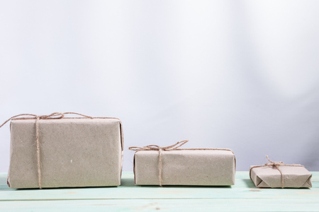 Presents for any holiday concept. Border of decorative gifts wrapped kraft paper tied with tourniquet for christmas, valentine day or birthdayの写真素材