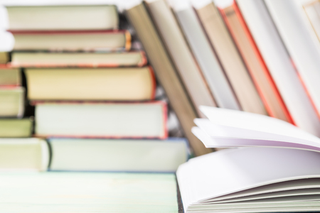 Open book and pile of various books on wooden background. With copy space for your textの写真素材
