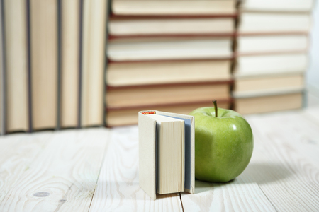 Stack of books and apple on the table. Copy space for text. Selective focus. Knowledge conceptの写真素材