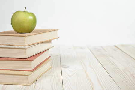 Stack of books and apple on the table. Copy space for text. Selective focus. Knowledge conceptの写真素材