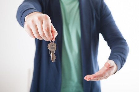 Bright picture of man hand holding house keysの写真素材
