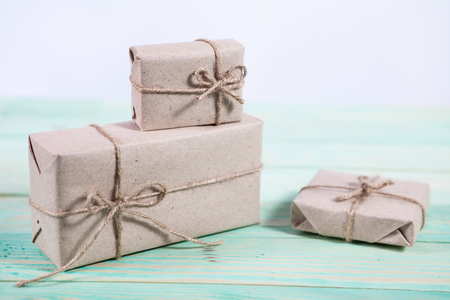 Presents for any holiday concept. Border of decorative gifts wrapped kraft paper tied with tourniquet for christmas, valentine day or birthdayの写真素材