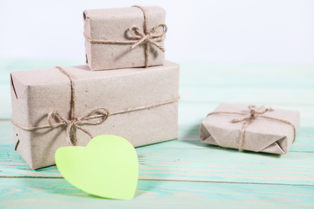 Gift boxes wrapped kraft paper tied with twine and sticker heart and tied with twine. with copy spaceの写真素材